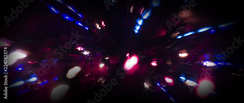 Neon sparks on a dark background. Neon light, laser. Blurred background. Abstract dark festive background.