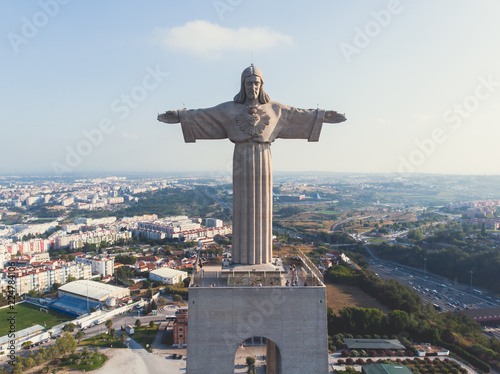 View of The Sanctuary of Christ the King, Cristo Rei, Almada, Lisbon, with 25 de Abril Bridge suspension Bridge, Tagus river, aerial drone view in summer sunny day photo