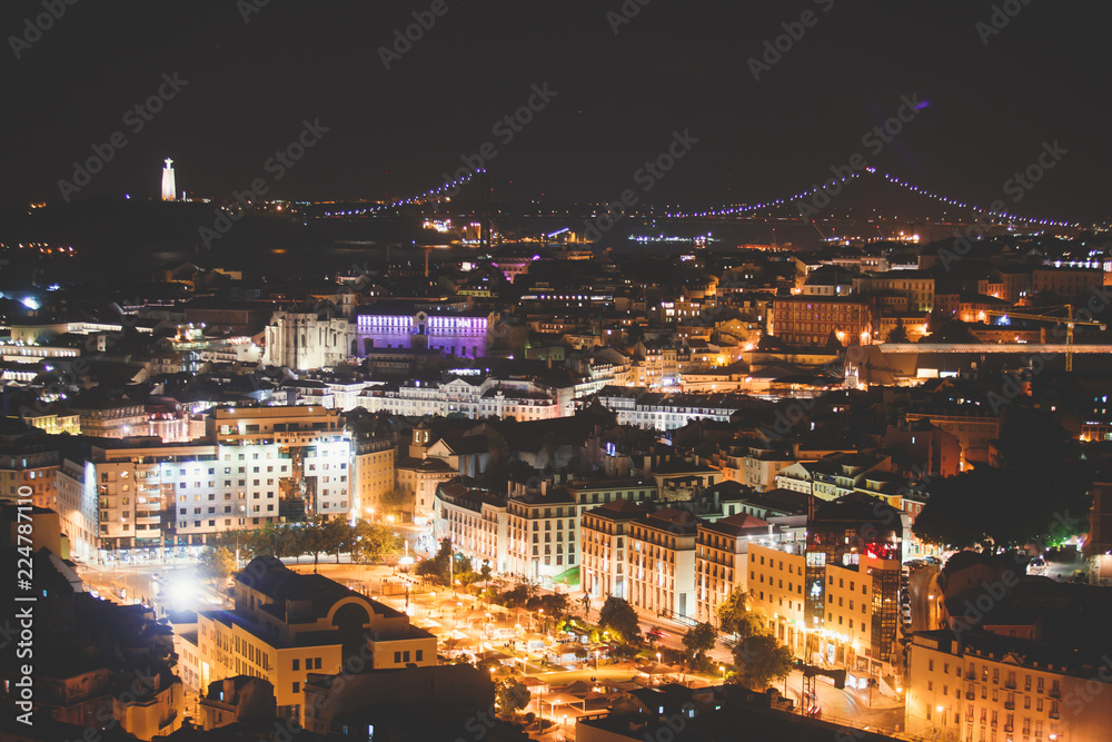 Fototapeta premium Beautiful night super wide-angle aerial view of Lisbon, Portugal with harbor and skyline scenery beyond the city, shot from belvedere observation deck