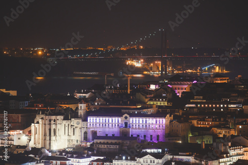 Beautiful night super wide-angle aerial view of Lisbon, Portugal with harbor and skyline scenery beyond the city, shot from belvedere observation deck