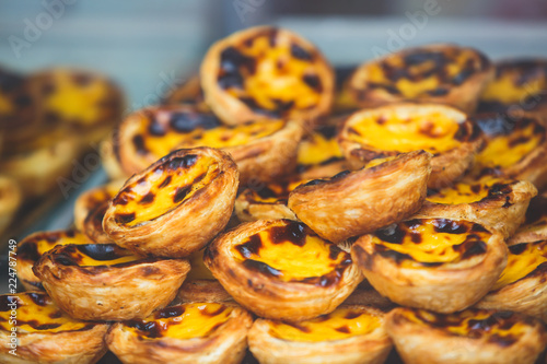 Traditional Portuguese egg tart pasty cakes, dessert Pasteis de nata with different portuguese pastry on the cafe store window, pastel de nata