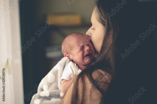 Obraz na płótnie Sweet crying newborn baby at mom on hand lifestyle