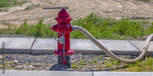 Fire pump with wrench on top and hose on nozzle photo