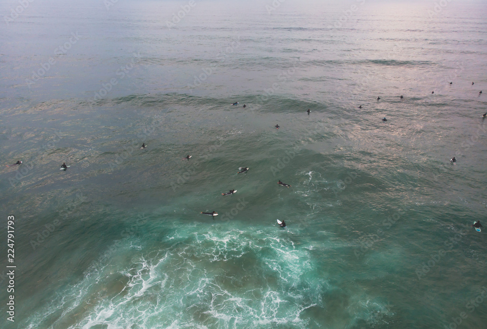 Obraz premium View of Praia do Guincho, Guincho beach, a popular Atlantic Ocean beach on Portugal's Estoril coast, municipality of Cascais, with surfers surfing on the waves, shot from drone