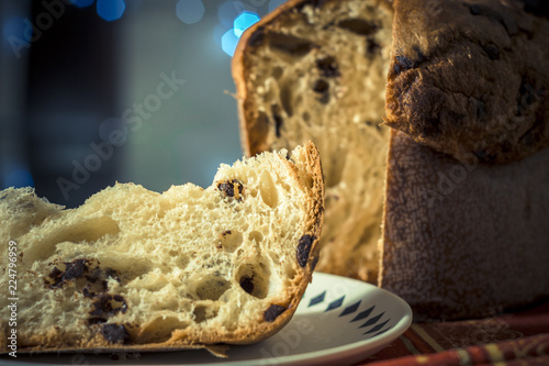 Panettone. Traditional italian dessert for christmas with chistimas light on background.