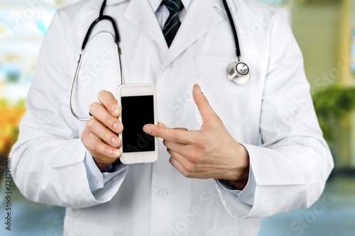 Close-up of male Doctor pointing at smartphone