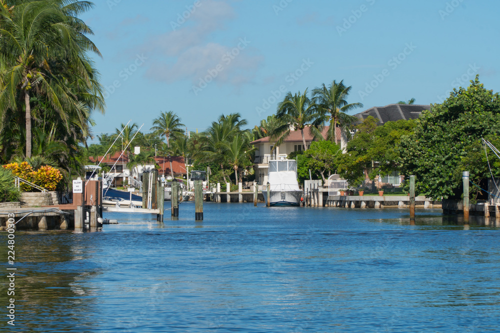 Day time view of coastal inlet in tropical island location with homes and private boat docks on river. Luxury expensive summer vacation homes