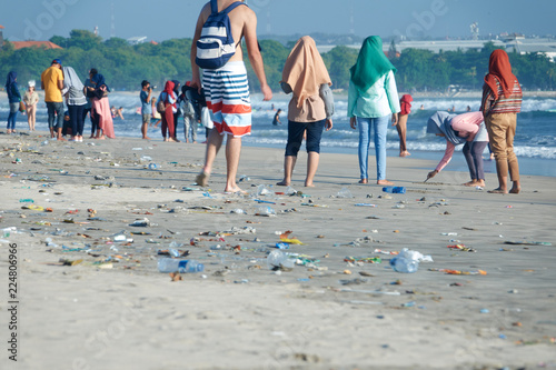 Tableau sur toile Trash on the Kuta beach in Bali. Many people walk among garbage
