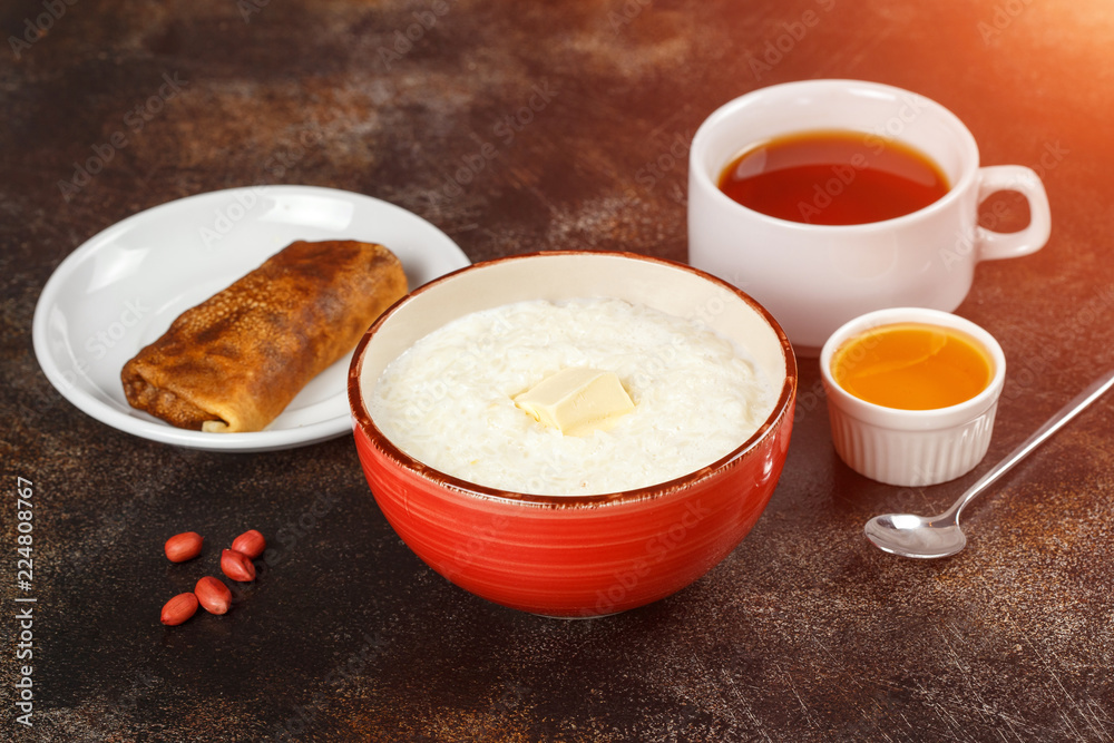 Oatmeal porridge in bowl, stuffed crepe and tea Oatmeal porridge in bowl, stuffed crepe and tea