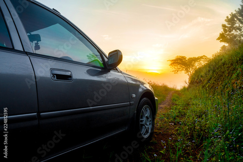 Travel concept car against sunrise and trail on mountains. Close Up photo of off-road wheel