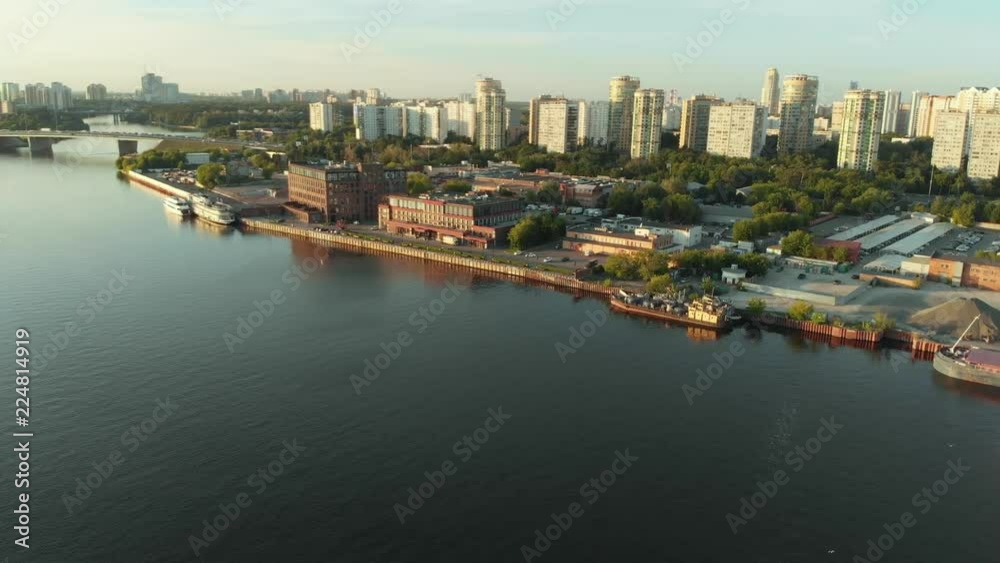 Panoramic view on river port with fleet barges anchored in water next to the river bank. Landscape with great wavy river Panoramic view on river port with fleet barges anchored in water next to the river bank. Landscape with great wavy river