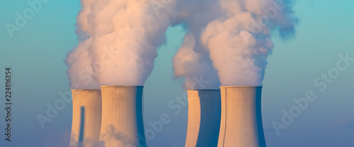 cooling towers with water steam in morning light, nuclear plant photo