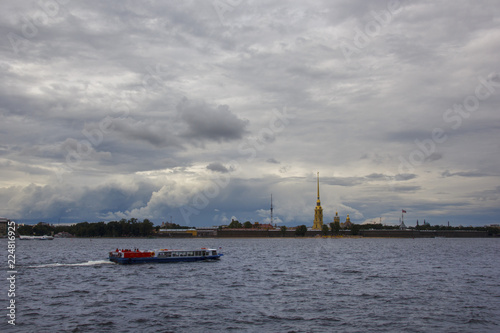 view from the Neva river with boats passing by to the Peter and Paul fortress, with a beautiful cloudy sky © Светлана Михалева