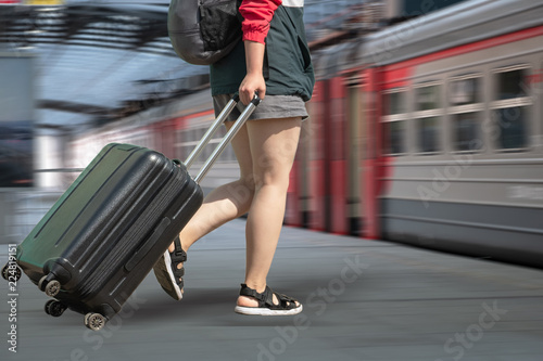 Legs of a girl with a suitcase.