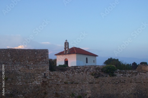 The christian orthodox church at the castle of Pantokratora in Preveza, Greece. Background view of the ambracian gulf. photo