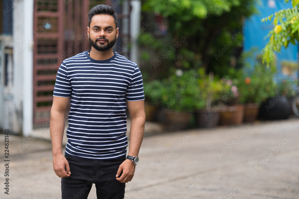 Fototapeta premium Young bearded Indian man in the streets outdoors