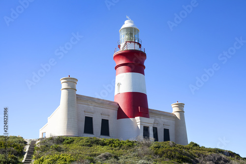Lighthouse on Cape Agulhas in South Africa on blue sky background, close up