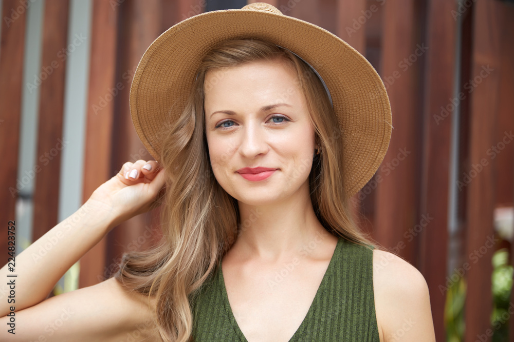 Beautiful stylish young woman in straw hat smiling at camera Beautiful stylish young woman in straw hat smiling at camera
