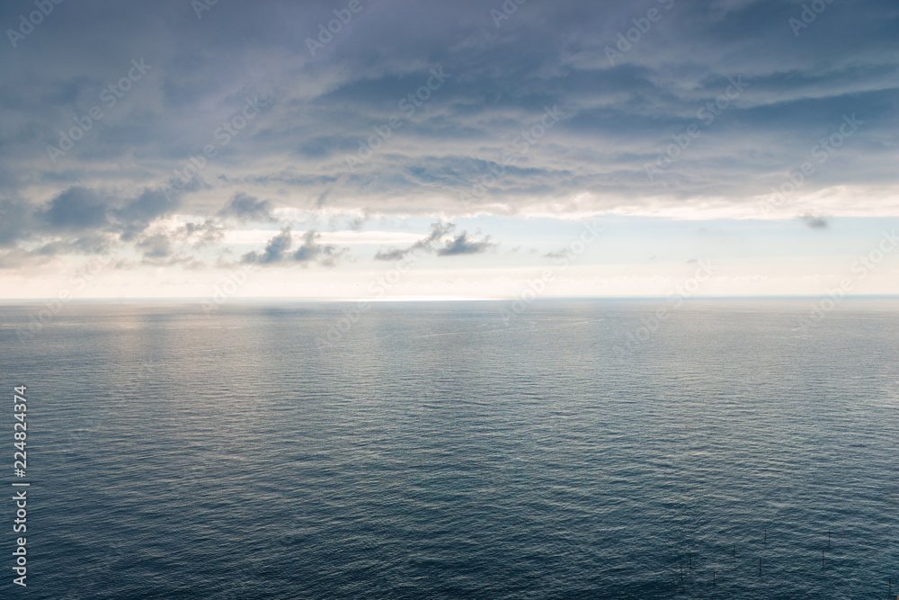 The surface of the sea with a slight ripple, a view of the horizon and heavy black rain clouds a beautiful landscape