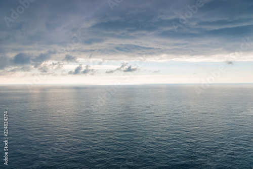 The surface of the sea with a slight ripple  a view of the horizon and heavy black rain clouds a beautiful landscape