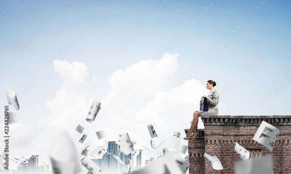 Fototapeta premium Businesswoman or accountant on brick roof against modern city sc