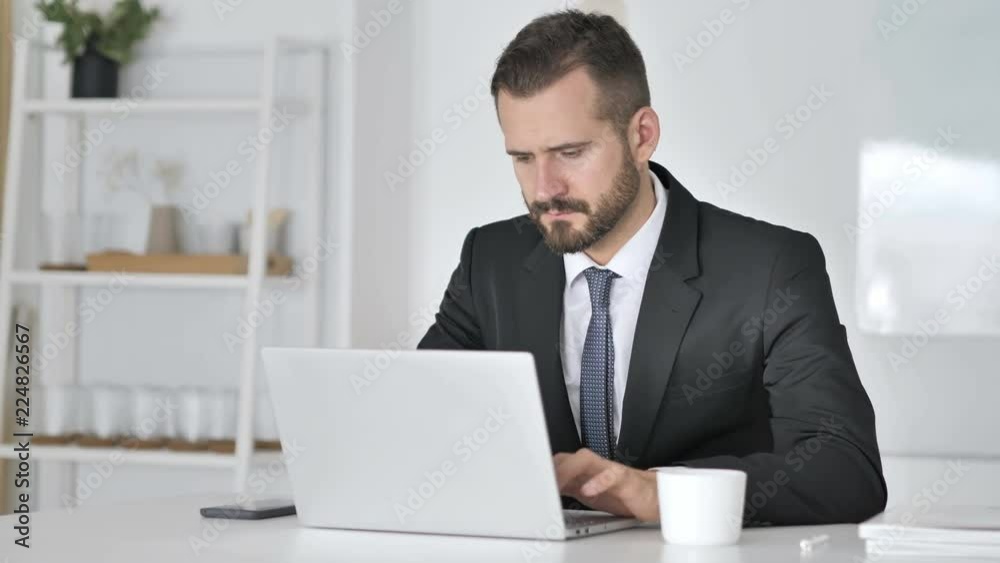 Busienssman Yawning while Working on Laptop Busienssman Yawning while Working on Laptop