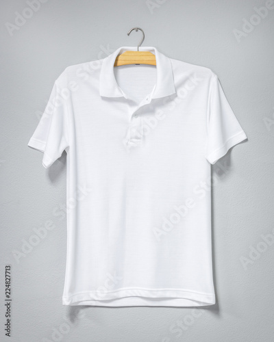 White shirt hanging on cement wall. Blank t-shirt for printing. Front view.