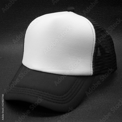 Black cap and white surface on dark background. Fashion hat for design. photo