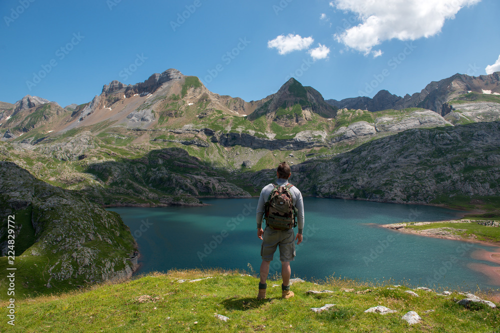 man hiker resting and  looking at lake in the Pyrenees mountains