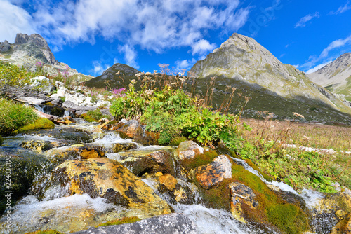 Water of a torrent flowing on stones into the mountain