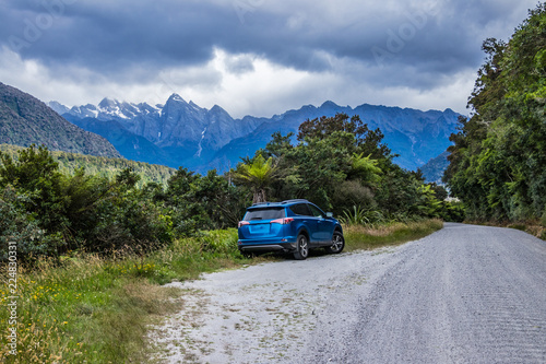 Blue car on roadside of wild country © Gabriel