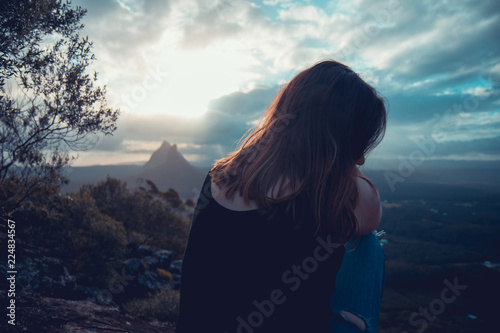 Female sitting on hill with picturesque view