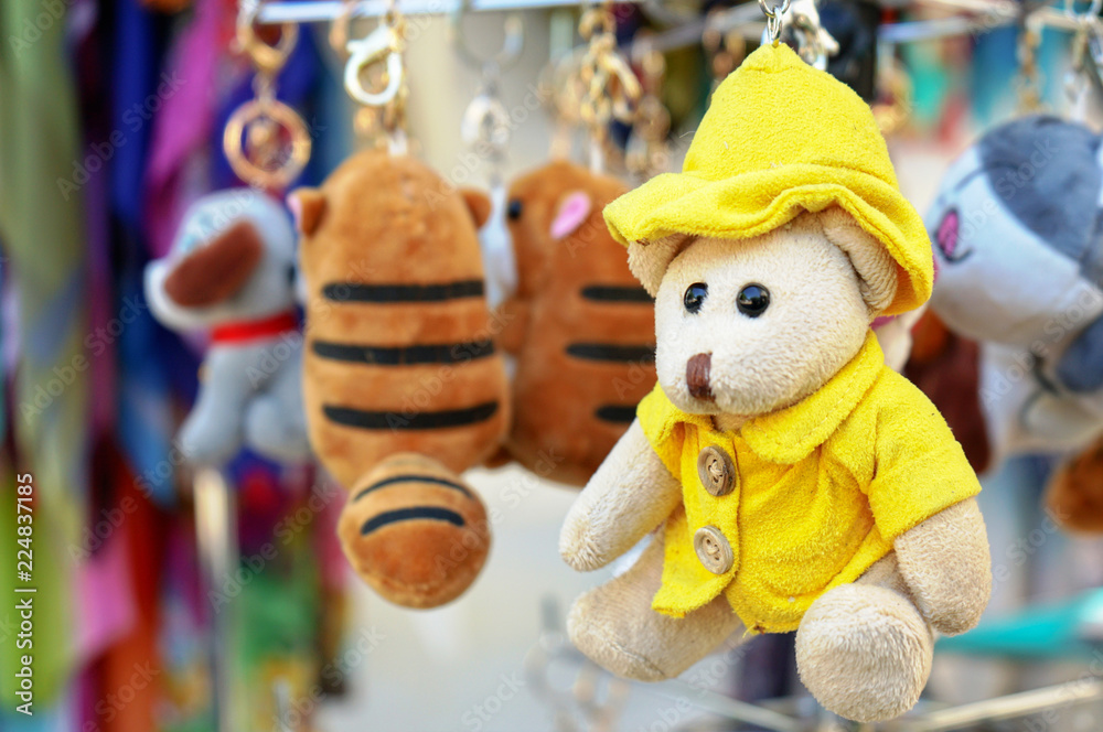 A small teddy bear in a yellow jacket and hat.
