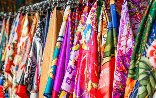 Many bright silk neckerchiefs on the store rack.