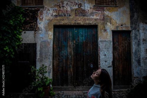 Young woman walking near building in old town © Gabriel