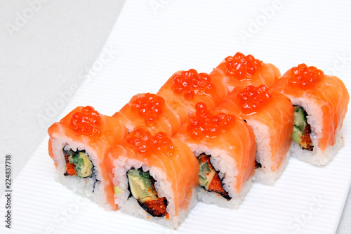 Roll with caviar of salmon. Sushi with caviar of flying fish. Japanese food on a beautiful dish.