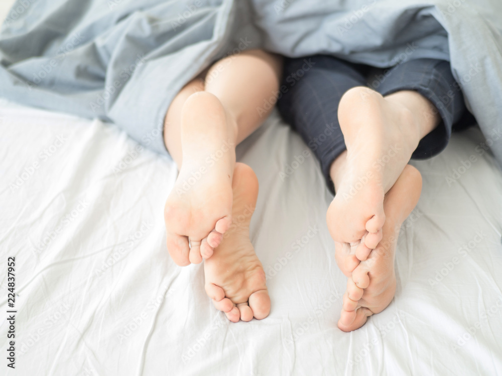 Close-up of the feet of a couple on the bed. Close-up of the feet of a couple on the bed.