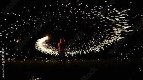 Sparks and fire twirling steel wool . Man spinning burning steel wool at night. photo