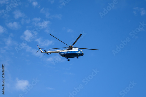 Russian helicopter flying high in the sky. Air transport on the background of clouds. 
