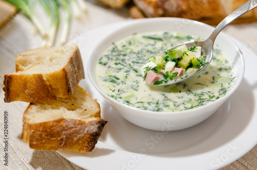 Traditional Cold Soup Okroshka with cucumber, sausage, potatoes, eggs, greens and sour cream.