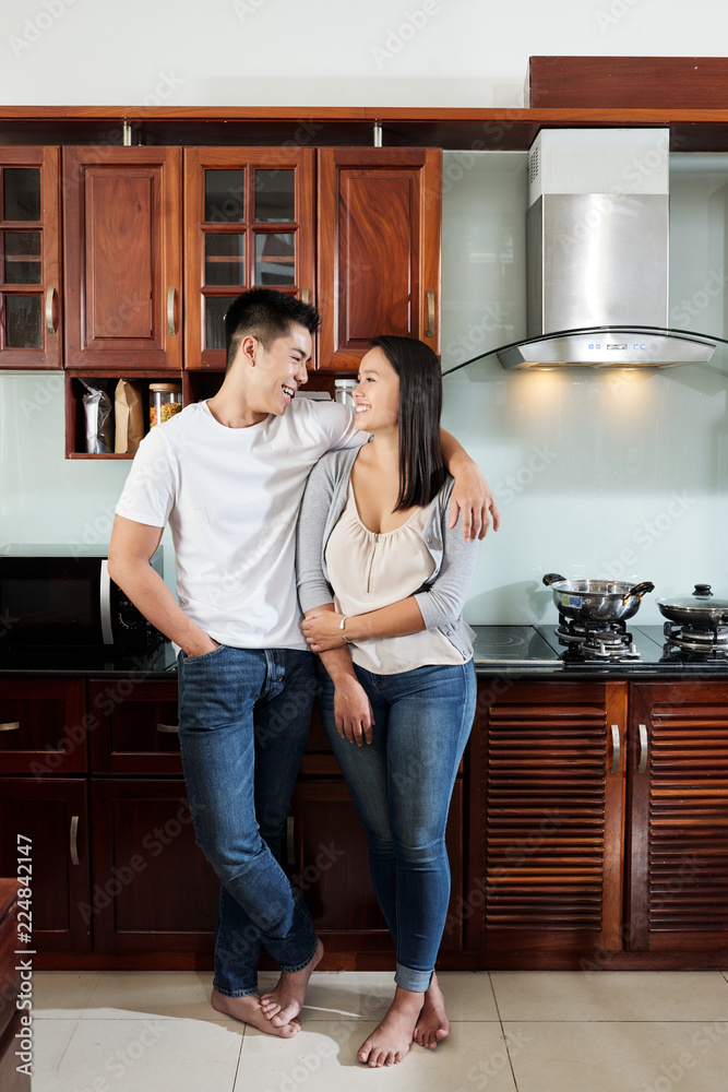 Happy Asian boyfriend and girlfriend hugging and looking at each other in new apartment Happy Asian boyfriend and girlfriend hugging and looking at each other in new apartment