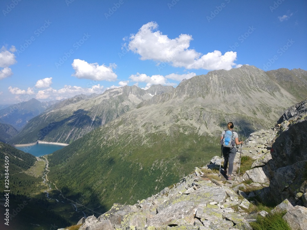 Hiking girl with backpack enjoying the view from the mountains