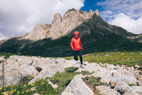 Woman trail runner running on beautiful mountains