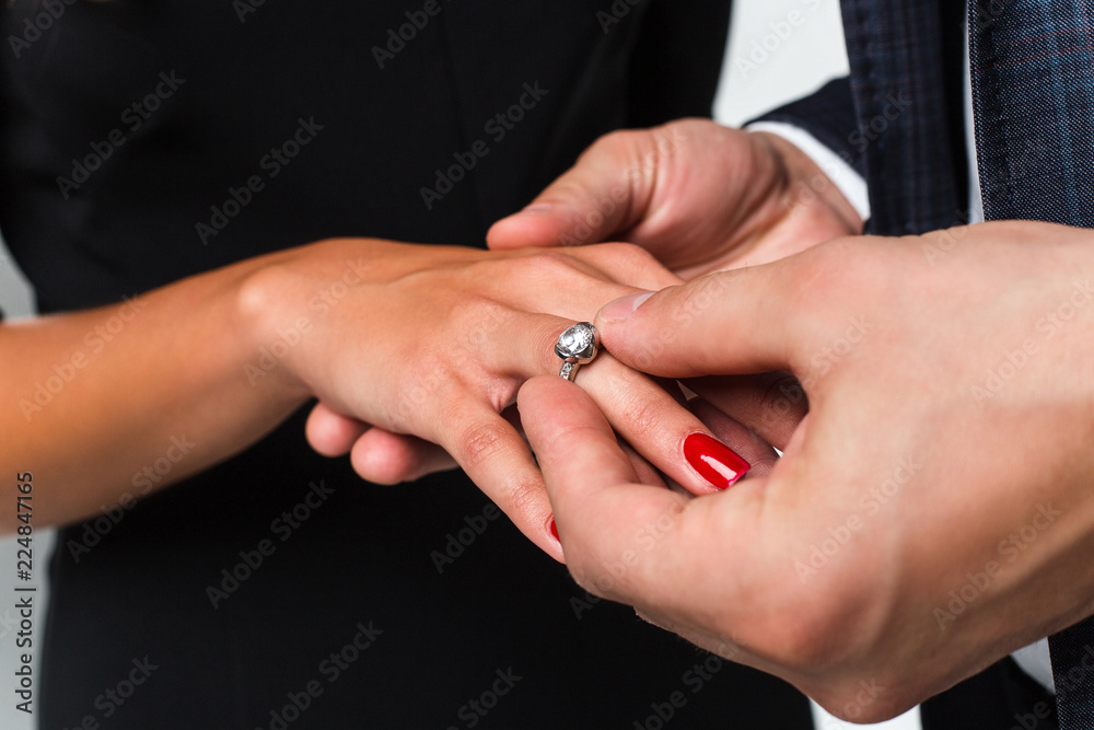 The perfect moment. Close-up of loving men putting ring to his girlfriend The perfect moment. Close-up of loving men putting ring to his girlfriend