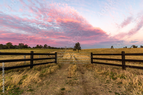 Country timber farm gate with colourful sky photo