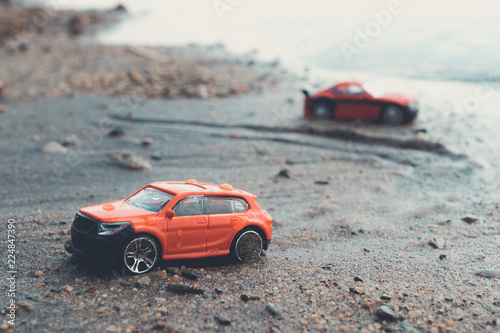 tinted photo of two red cars on the beach in summer