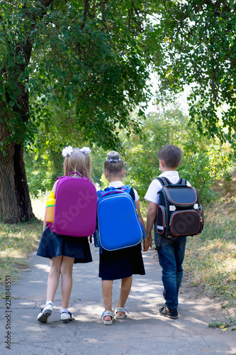 Three elementary school students with backpacks