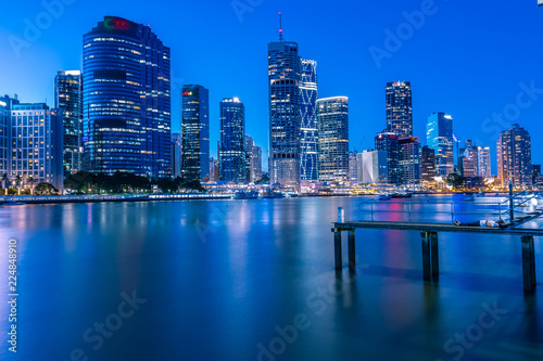 Human laying on pier and city's skyline behind