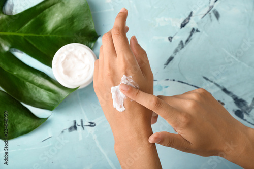 Woman applying hand cream, top view