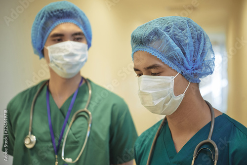 Obraz na plátně Team of medical wokers in scrubs, masks and medical hats ready for surgery